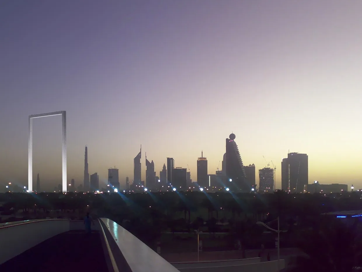 Dubai Frame в ночной подсветке: золотистые опоры рамки светятся тёплым светом на фоне тёмного неба